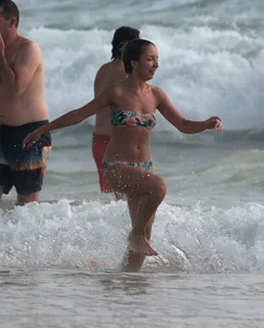 Cute skinny girl in a bikini at the beach playing in the water
