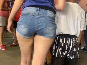 Bunch of girls in various outfits at a Cardinals baseball game