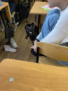 College Candid Teen in Pantyhose And a Skirt Putting On Her Sneakers in Classroom