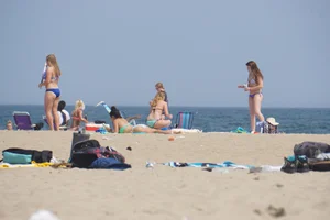 Cute girls in light blue and purple bikinis on the beach