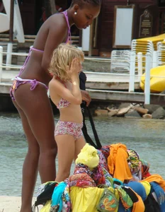 Sexy black babe in various bikinis on the beach while on vacation