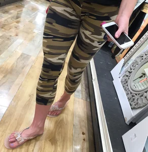 Closeup of awesome long legs in camo leggings and feet in sandals