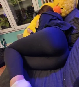 Girl in tights curled up on the couch home creepshot