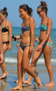 Foursome bikini friends walking the beach