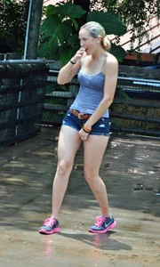 Cute blonde in denim shorts and a wet top