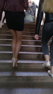 Hot girl walking up the stairs, wearing a skirt, pantyhose and high-heeled shoes