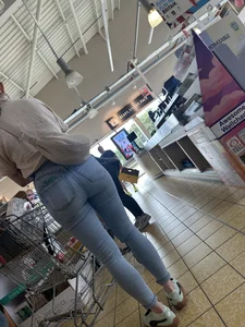 Tight cheek hugging jeans on brunette in line at shop