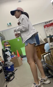 Tight bum hanging out of jean shorts in thrift shop