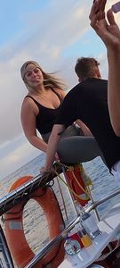 Blonde bending over on a boat in leggings