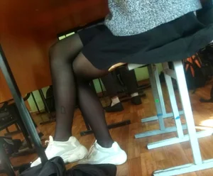 Crossed Legs of a Candid College Teen in a Skirt And Black Pantyhose Under Desk Photo