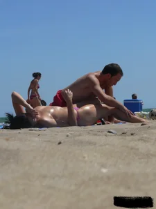 Purple thong topless lady on the beach gets oiled up by her husband