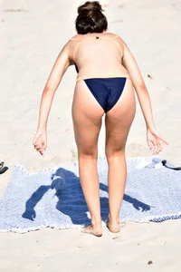 Blue bikini girl on the beach with a great ass and a little pussy lips slips