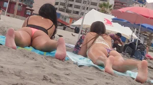 Pink and patterned bikini girls' asses laying on the beach