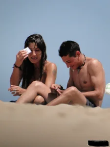 Topless lady on the beach in a gold thong with a nice ass