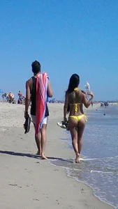 Beach babe with a nice ass and big tits in yellow thong bikini