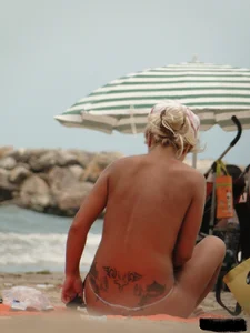 Tattooed blonde with big tits topless and in thong