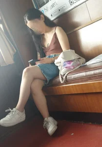 A Skinny And Flat-Chested Candid Girl in Shorts Sitting With Crossed Legs Creepshot