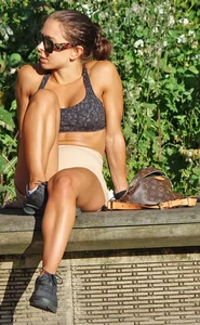 Tanned fitness woman showing off her toned physique & amazing butt