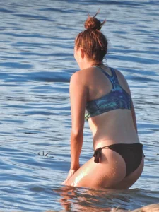 Sexy beach girl in a Nike sports bra and black bikini bottom