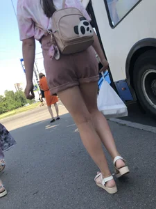 Young Girl in Sandals and Shorts in a Public Bus