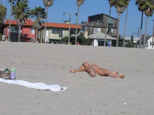 Sexy milf doing yoga in a bikini at the beach