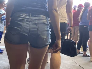 Bunch of girls in various outfits at a Cardinals baseball game