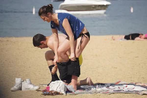 Sexy girl on the beach laying out and bending over in her bikini