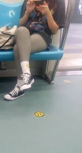 Girl in Grey Leggings Sitting With Crossed Legs in a Subway Train