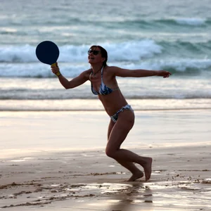 Older lady playing on the beach in her bikini