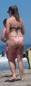 Chunky beach blonde babe in a pink thong bikini