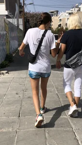 Cute skinny teen in shorts walking down the street
