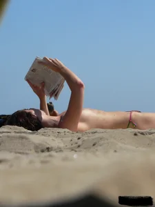 Topless beach milf looking sexy in a tiny g-string bikini