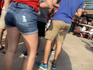 Bunch of girls in various outfits at a Cardinals baseball game
