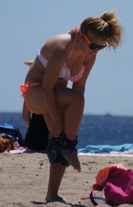 Thick blonde girl in an orange bikini on the beach
