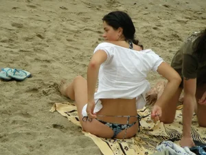 Sexy girl in a blue floral thong bikini at the beach