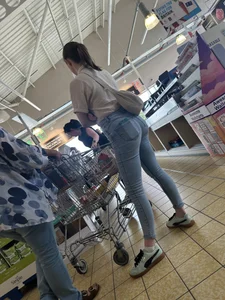 Tight cheek hugging jeans on brunette in line at shop