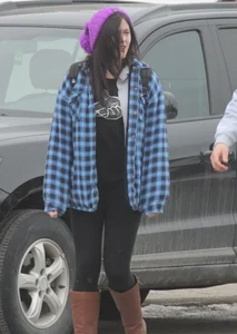 A cute brunette in leggings boots and hat