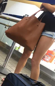 Sexy brunette waiting in line with short jean shorts