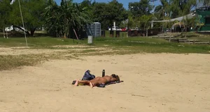 Sexy girl getting some sun laying on the beach in thong bikini