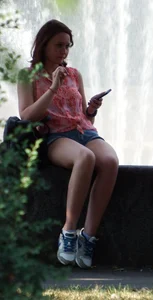 Cute Girl in Denim Shorts and Sneakers Sitting by a Fountain City Candid Creepshot