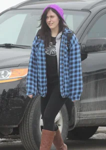 A cute brunette in leggings boots and hat