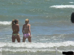 Sexy blonde on the beach in a yellow thong bikini