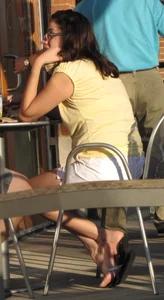 Lady in flop flops while eating showing her feet