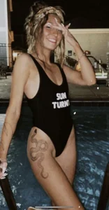 Non-candid girl with a snake tattoo coming out of the pool