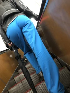 Booty of a candid girl standing on subway escalator low angle creepshots