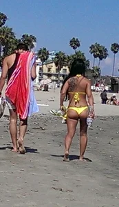 Beach babe with a nice ass and big tits in yellow thong bikini