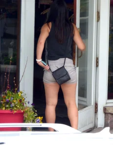 Thick brunette listening to music in shorts