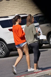 Brunette in tiny shorts walking with her sexy friend in leggings