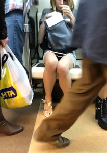 Girl in a Denim Skirt and Sandals in a Subway Train Creepshot