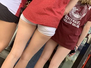 Bunch of girls in various outfits at a Cardinals baseball game
